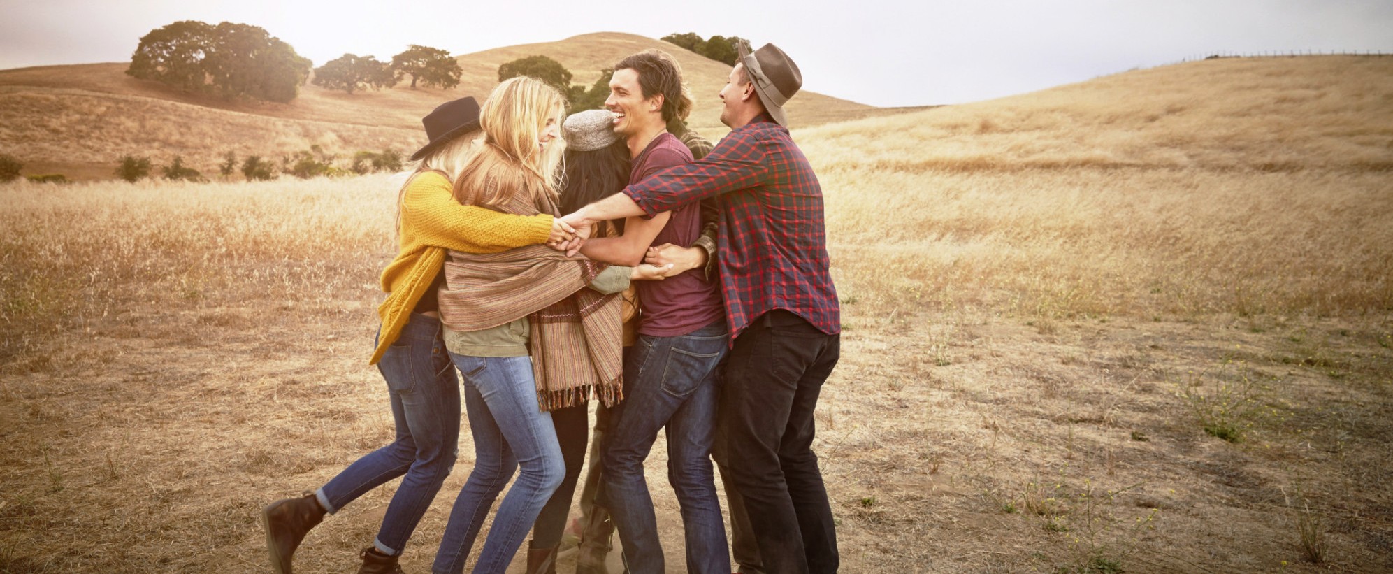 Friends hugging in rural landscape
